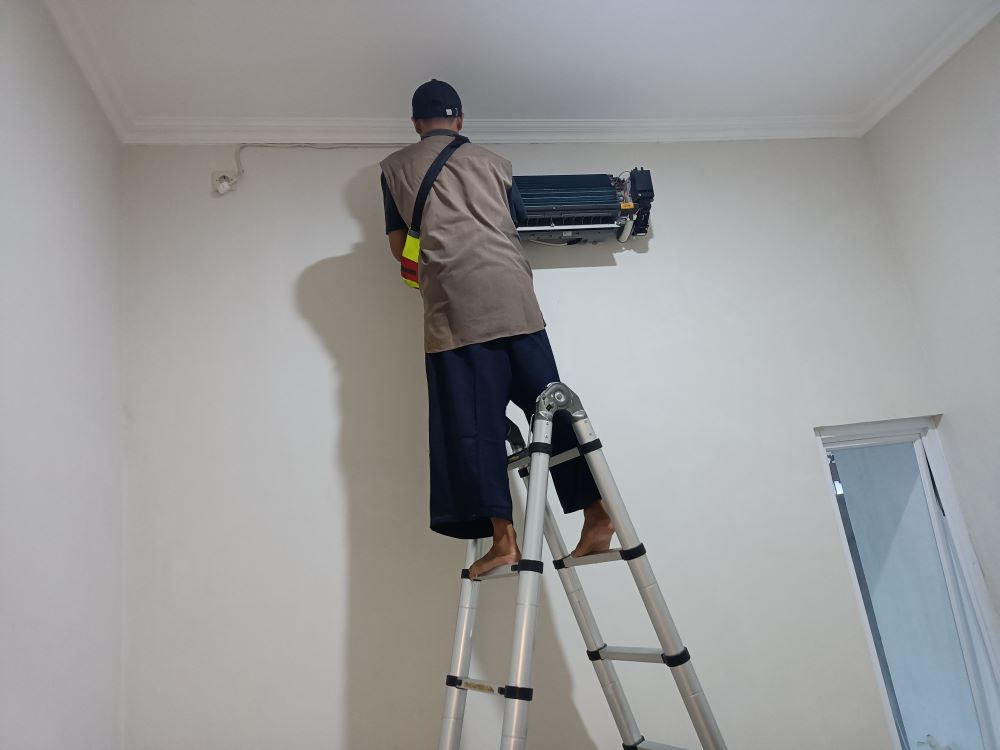 Teknisi sedang memperbaiki mesin cuci